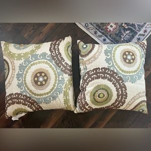 Beautiful patterned pillows with cream, brown, blue and green colors.